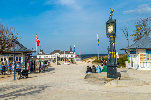 people enjoy Pier and Beach of Ahlbeck at baltic Sea with view to world famous pier with hut, built in 1899.
