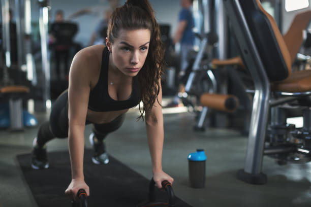 istock Beautiful woman in the gym doing push ups 642343704