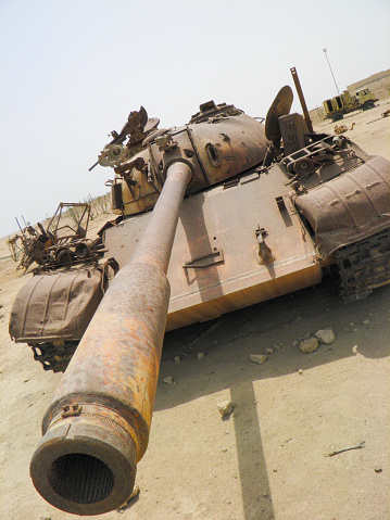 The photo shows a rusted tank from the Iraq and Kuwait war. The tank is part of a field filled with damaged tanks and armored vehicles used during the war. The photo was taken in the Failaka Island a few miles off of Kuwait city, Kuwait.