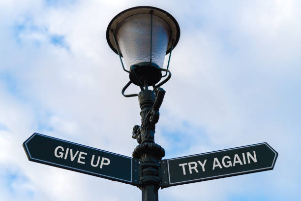 istock Give Up versus Try Again directional signs on guidepost 642367666