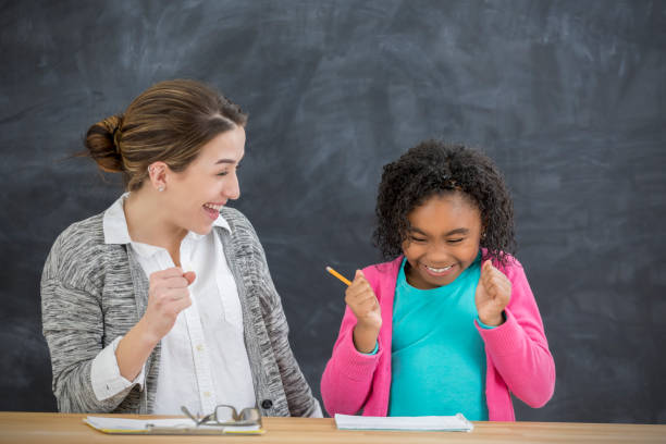 A teacher helps a student with the lesson in class.