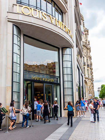 People Queue Up In Front Of Louis Vuitton Shop Stock Photo
