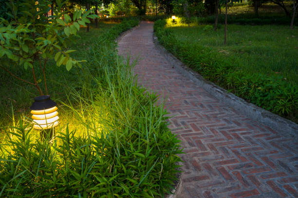 istock Twilight garden scene with lamp and brick curved road 642448362