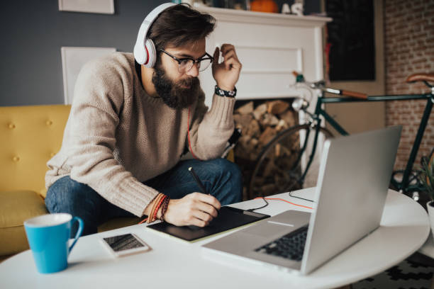 Interior designer working from his cozy home office Interior designer working from his cozy home office editing equipment stock pictures, royalty-free photos & images