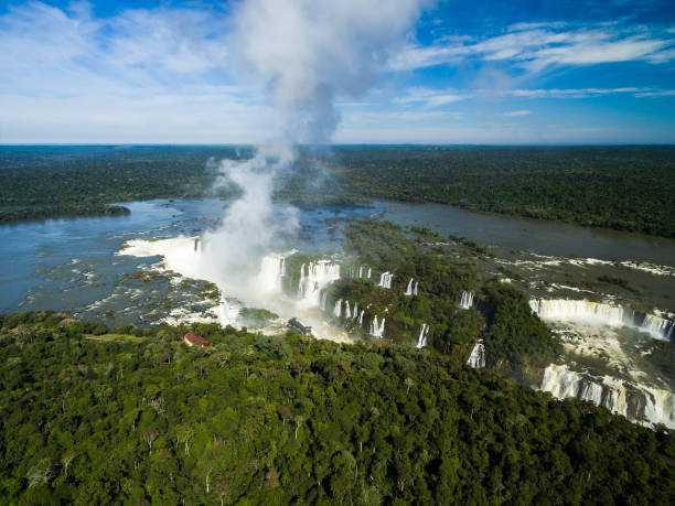 vista aérea de iguazu cai entre a fronteira de brasil e argentina - tropical rainforest waterfall rainbow iguacu falls - fotografias e filmes do acervo