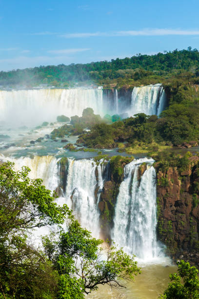 cataratas do iguaçu, entre a fronteira de brasil e argentina - tropical rainforest waterfall rainbow iguacu falls - fotografias e filmes do acervo