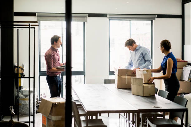 Business people packing boxes at table in office