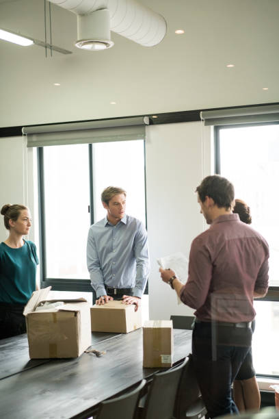 istock Business people with cardboard boxes at table 642479786