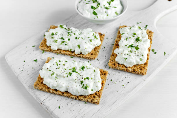 домашний тост crispbread с творогом и пет�рушкой на белой деревянной доске. - ricotta cheese freshness white стоковые фото и изображения