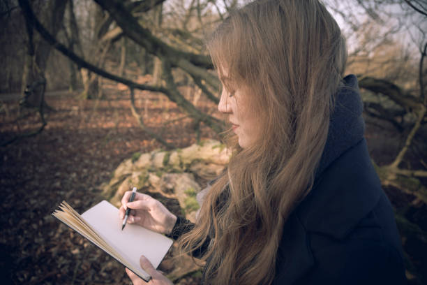 istock Attractive young woman writing in her journal 642497782