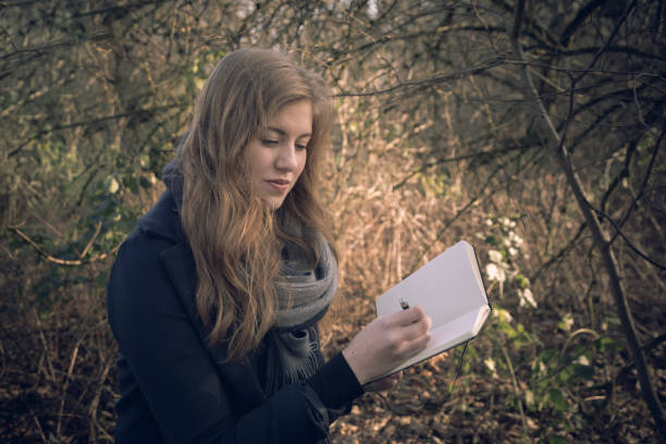 istock Attractive young woman writing in her journal 642498182