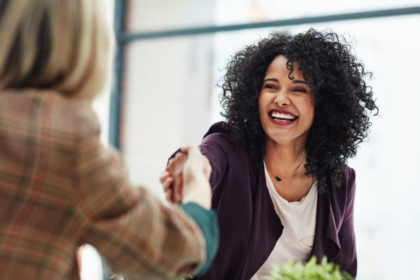 Wonderful, I'll see you first thing on Monday Shot of two colleagues shaking hands during a meeting at work professional woman smiling stock pictures, royalty-free photos & images
