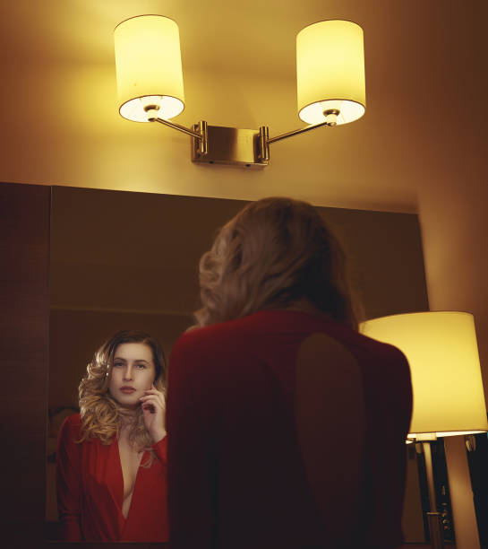 istock elegant woman looking in the mirror 642501994