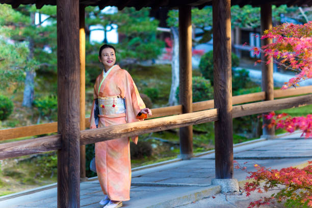 istock Woman in a kimono walking through a temple corridor 642509088
