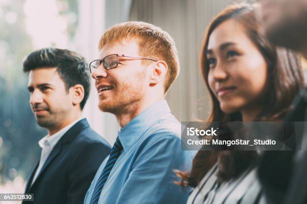 Business People Listening To Speaker And Smiling Stock Photo - Download Image Now - Audience, Curiosity, Listening