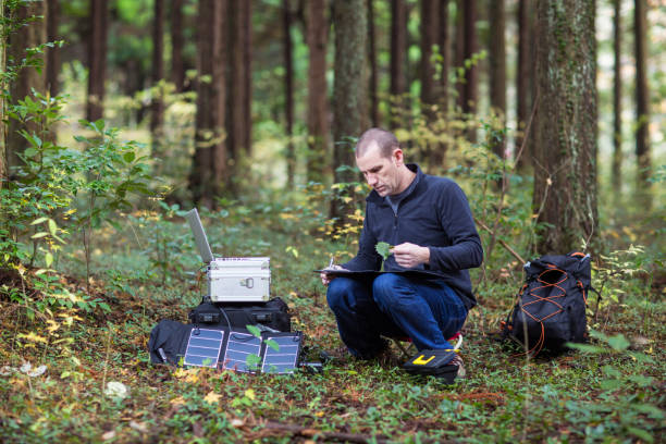 istock Scientist gathering data in forest with solar powered field station. 642513422