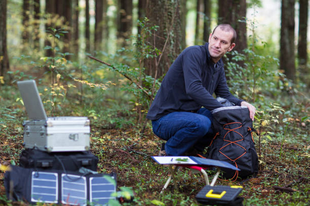 istock Scientist gathering data in forest with solar powered field station. 642513424