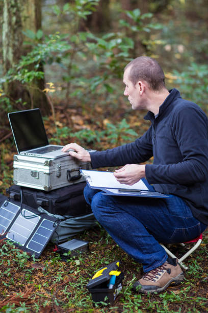 istock Botanist gathering data in forest with solar powered field station. 642513430