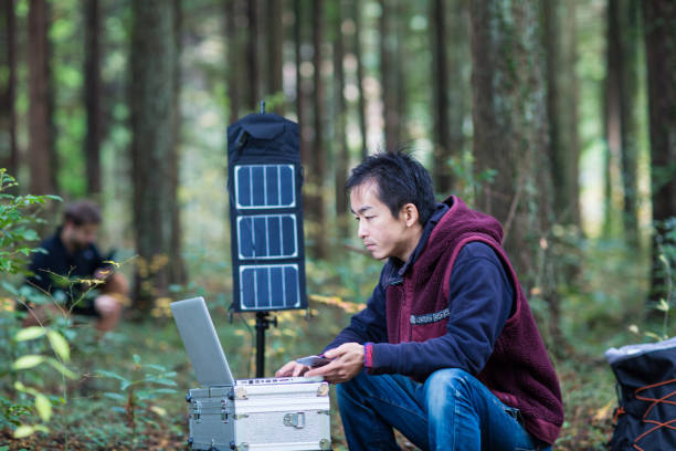 istock Two researchers work in the forest with solar powered field laboratory 642515450