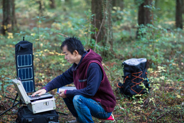 istock Scientist gathering data in forest with solar powered field station. 642515490