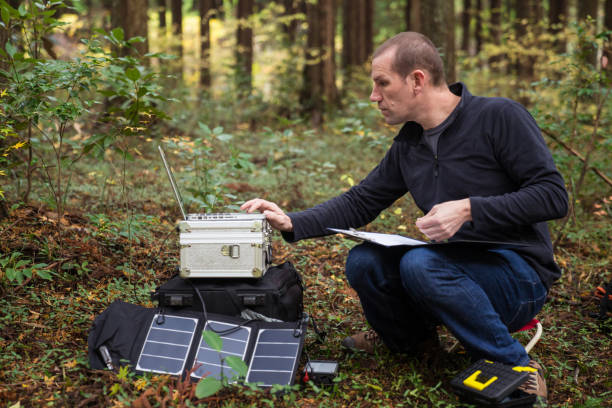 istock Botanist gathering data in forest with solar powered field station. 642515528
