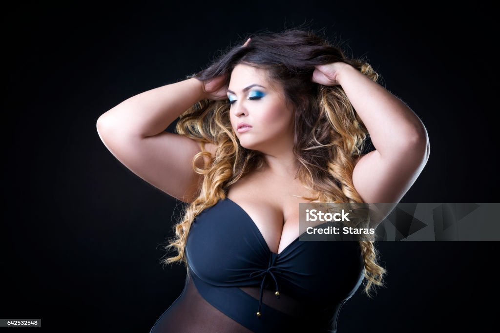 Plus size model with big breast in black bra Young beautiful caucasian plus size model with big breast in black bra, xxl woman on black background Large Stock Photo