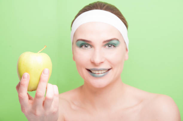 istock Attractive smiling woman showing healthy apple 642536054