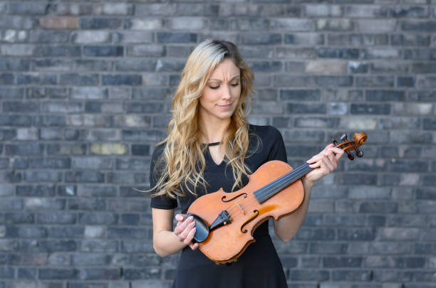 istock Woman looking at violin in her hands 642545586
