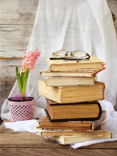 istock Stack of old hardback books and hyacinth on wooden background. Selective focus. Copy space 642546148