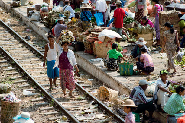 большой рынок на платформе станции и вдоль железнодорожного пути.  22 февраля 2014 г. - железнодорожный вокзал даньиньон, янгон, мьянма - burma railway стоковые фото и изображения