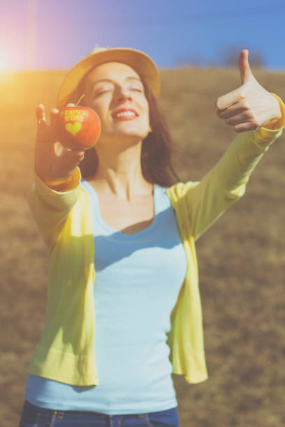 istock woman with apple in the nature 642570232