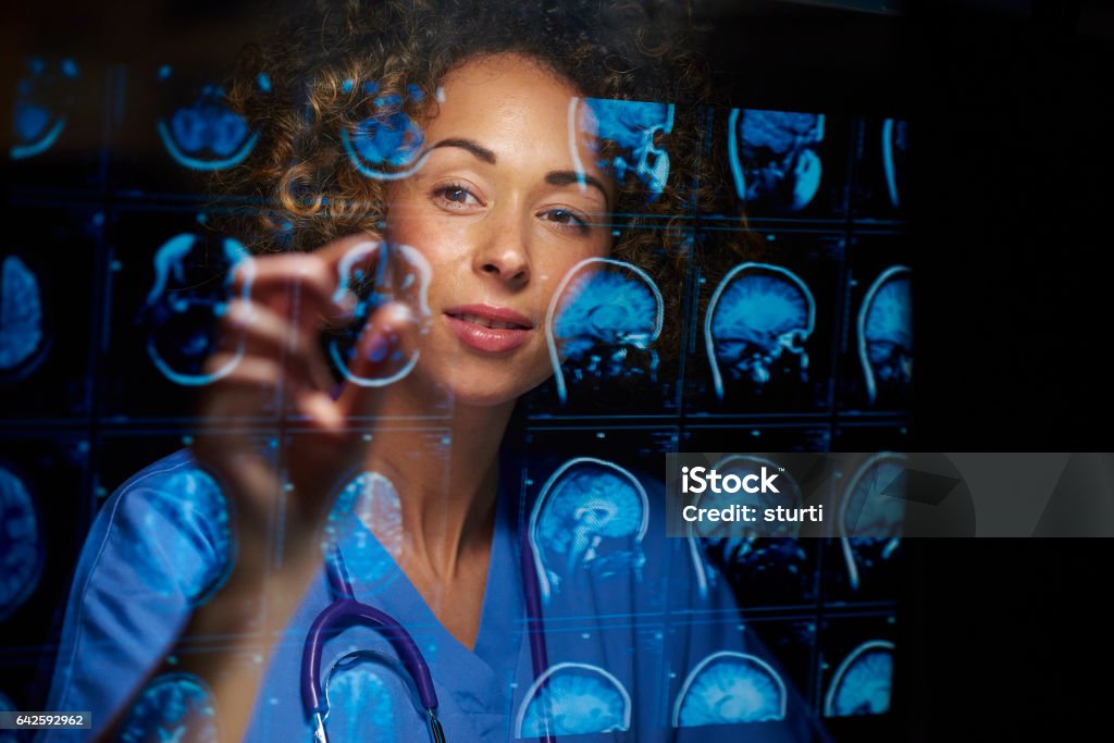 female neurosurgeon a female doctor or surgeon is analysing the digitally generated scans of a human brain Oncologist Stock Photo