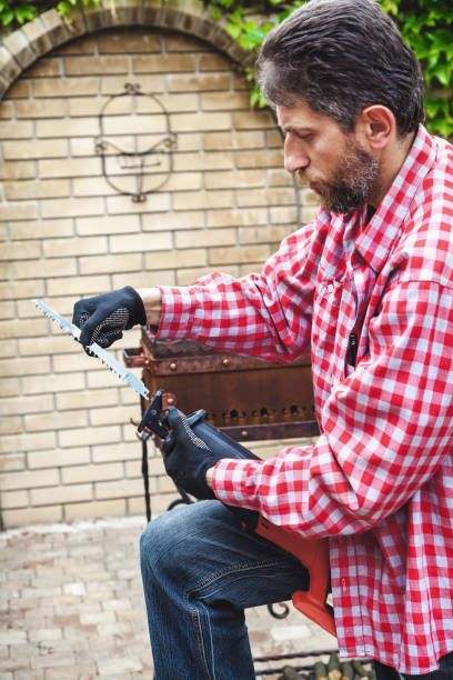 istock man in plaid shirt inserts in electric saw handsaw 642598222