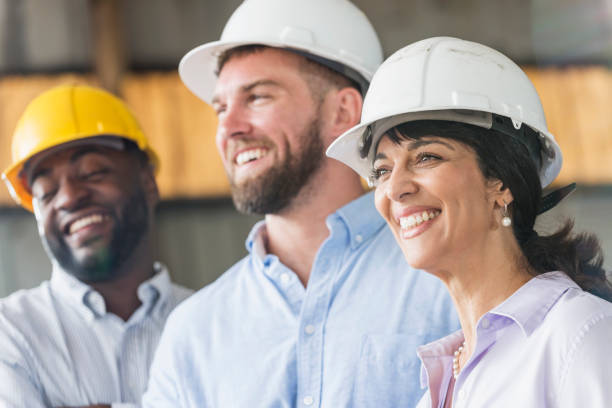 istock Hispanic woman with group of workers in hardhats 642610488