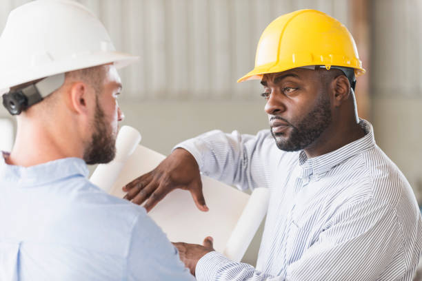 istock Two men in hardhats discussing blueprints 642610498