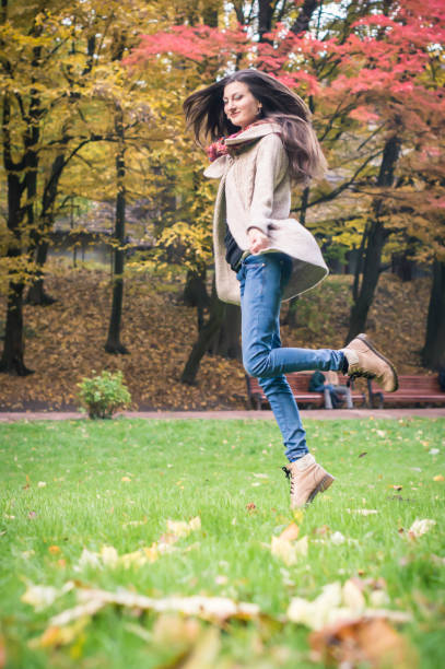 istock happy girl jumping on grass 642634652
