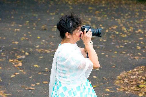 Asian female photographer taking photos with her DSLR camera, Sydney, Australia, full frame horizontal composition with opy space