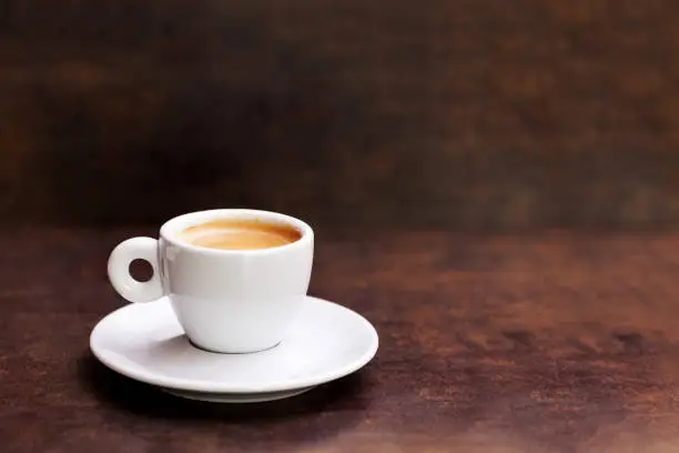 Photo of White cup of espresso coffee on background