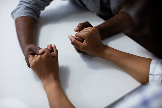 istock Close-up of couple holding hands on table in kitchen 642644416