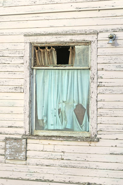 istock Abandoned building with boken window and torn curtains 642646706