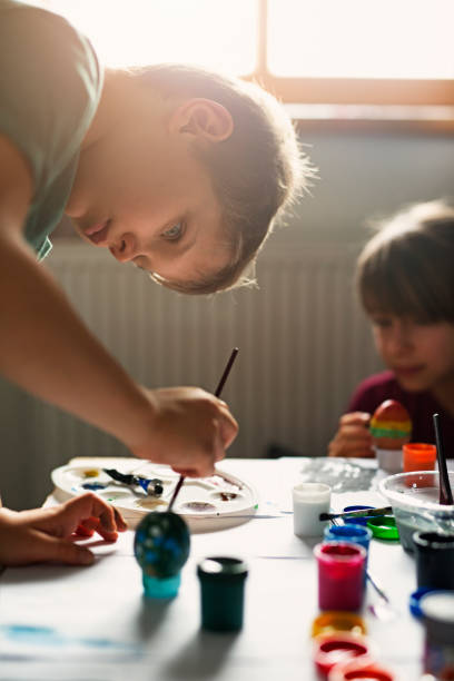 istock Brother and sister painting easter eggs 642647024