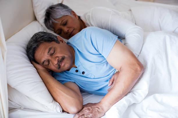 istock Senior couple sleeping together on bed in bedroom 642655508