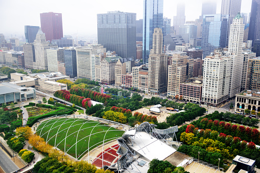 Aerial view of South Michigan Avenue in The Loop, downtown Chicago. Cityscape with distant people  and  landmark  architecture.  Pritzker Pavillion and Millennium Park in the foreground. Misty autumn day.