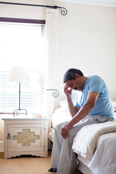 istock Tensed senior man sitting on bed 642656220