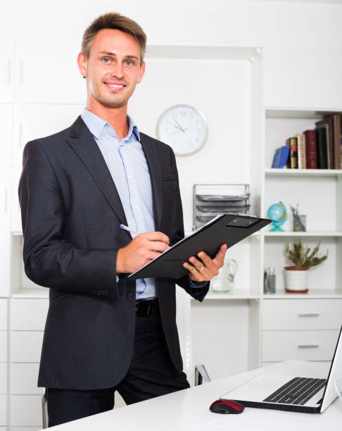 istock young man holding clipboard in office 642662530