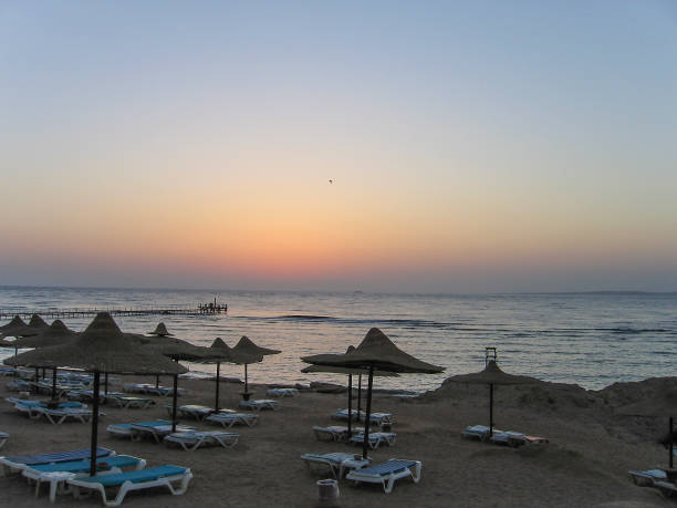 Red Sea in Egypt during sunrise with blue water and beach with umbrellas and chairs