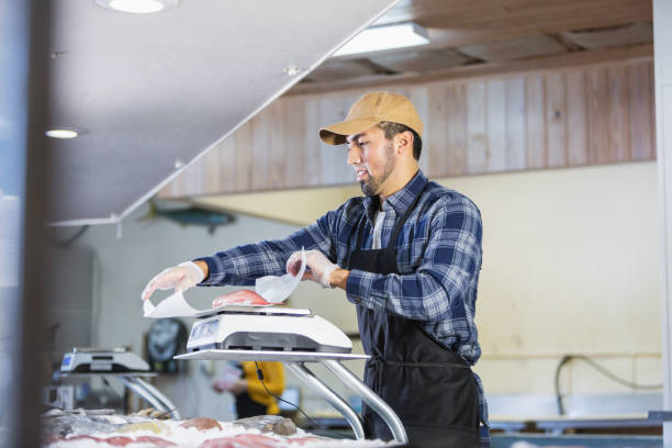 istock Hispanic man working in seafood market, weighing fish 642673970