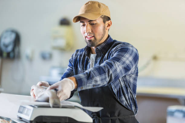 istock Hispanic man working in seafood market, weighing fish 642673990