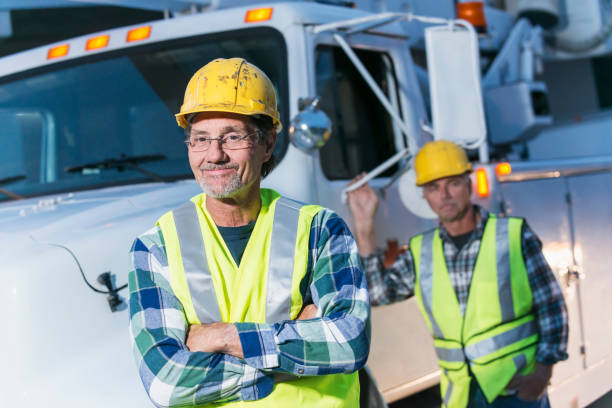 istock Two workmen in safety vests with truck 642677596