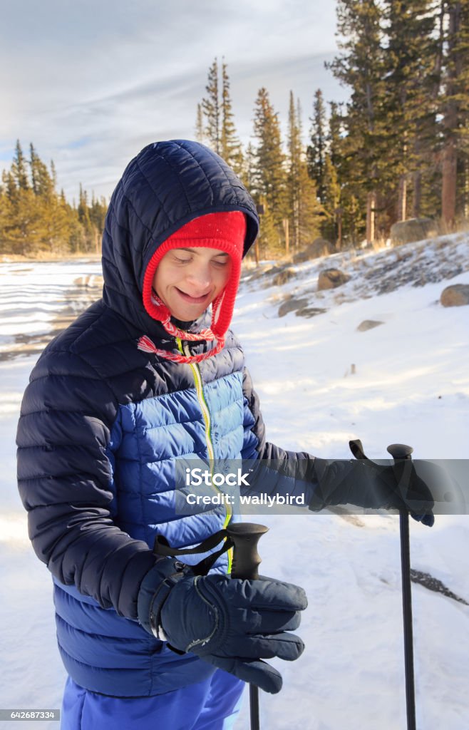 Happy Teenager with Down's Syndrome and autism snowshoeing vertical orientation color image of an attractive teenage boy with Down's Syndrome and autism snowshoeing in the forest, "CreativeContentBrief" Down Syndrome Stock Photo